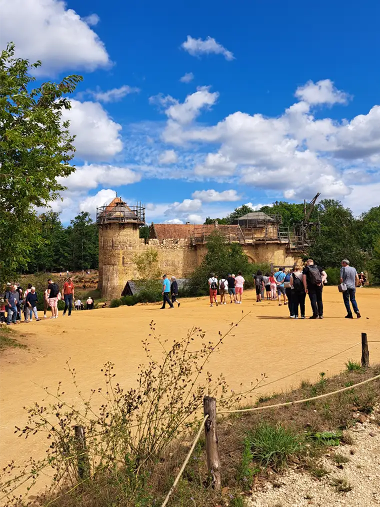 Visitantes frente al castillo en construcción de Guédelon