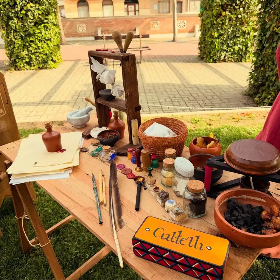 Mesa de reconstrucción histórica con útiles de escritura y objetos de cultura material medieval