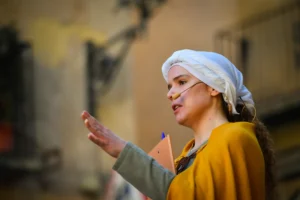 Guía caracterizada explicando historia medieval en proyectos de divulgación histórica